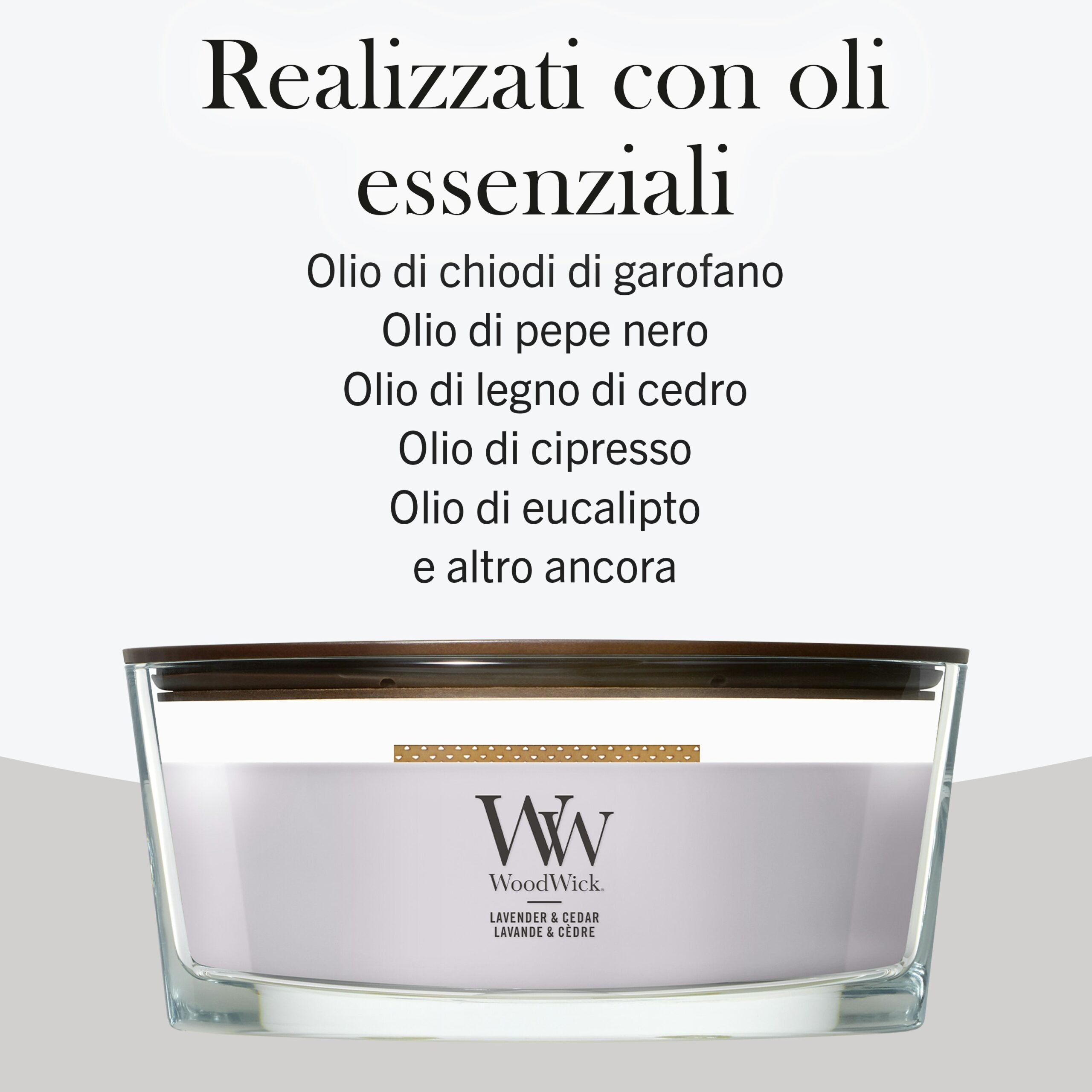 Lavender and Cedar – Ellipse – WoodWick Ellipse 3 Una candela Candela Ellipse con stoppino in legno di lavanda e cedro riposa sotto una didascalia in italiano che descrive in dettaglio gli oli essenziali — chiodi di garofano, pepe nero, legno di cedro, cipresso ed eucalipto — utilizzati nel prodotto, sottolineandone la miscela rilassante di fragranze di lavanda e cedro.