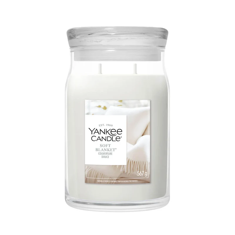 Soft Blanket – Giara Grande – Yankee Candle 350 Punti Una candela in un grande barattolo di vetro denominata “Soft Blanket - Giara Grande - Yankee Candle” è realizzata in cera bianca, ha due stoppini e presenta un’etichetta che raffigura una morbida coperta e un orsacchiotto su un letto.