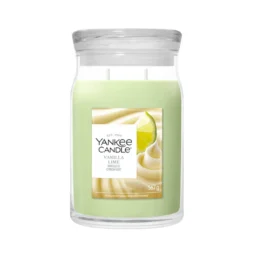 Una candela Yankee Candle “Vanilla Lime Giara Grande” in barattolo di vetro con coperchio trasparente e cera verde chiaro, con immagini di panna montata e una fetta di lime sull’etichetta.