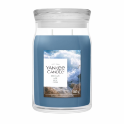 Ocean Air - Giara Grande - Yankee Candle presenta una candela di cera blu contenuta in un grande barattolo da 567 grammi con coperchio in vetro trasparente. L'etichetta raffigura le onde dell'oceano che si infrangono sugli scogli.