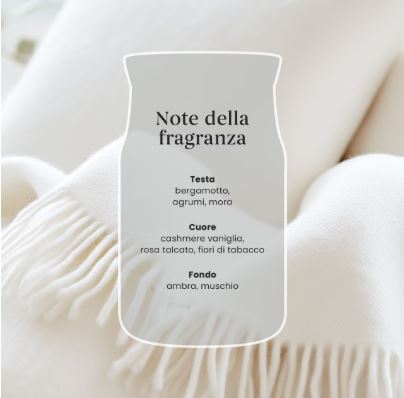 Soft Blanket – Candela Piccola – Yankee Candle 100 Punti 2 Una coperta intrecciata color crema con frange, accompagnata da un foglietto trasparente che elenca le note olfattive di ispirazione italiana della fragranza “Soft Blanket - Giara Grande” di Yankee Candle: bergamotto, agrumi, mora, vaniglia, rosa, talco, fiore di tabacco, ambra e muschio.