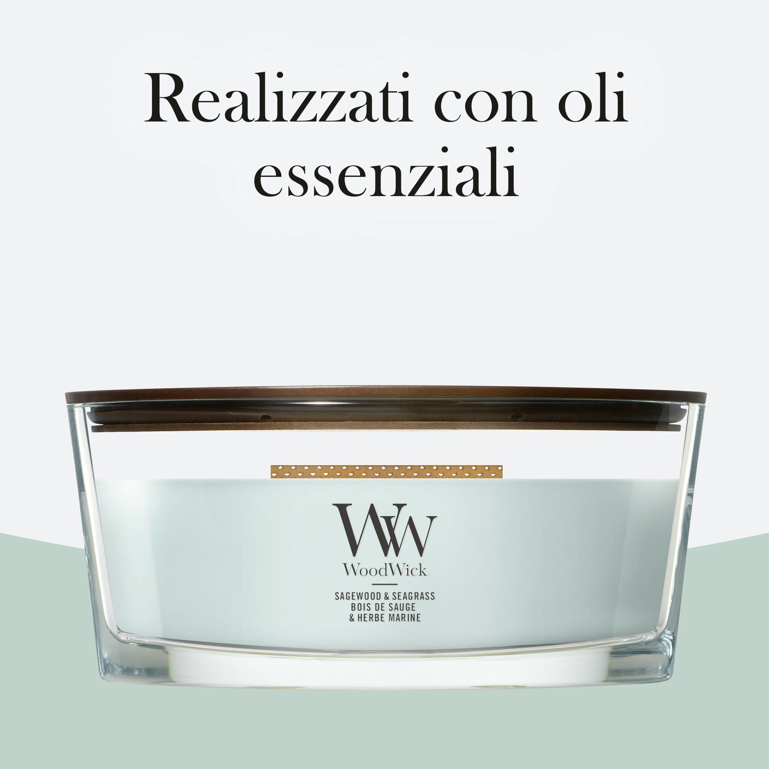 Sagewood & Seagrass – Candela Ellipse – WoodWick Ellipse 4 La candela “Sagewood & Seagrass - Candela Ellipse - WoodWick”, caratterizzata dal coperchio in legno e dall’etichetta verde chiaro, è esposta sotto una scritta in italiano che recita “Realizzati con oli essenziali”. La sua rilassante fragranza di legno di salvia ed erba marina pervade l’aria, creando un’atmosfera fresca e naturale.