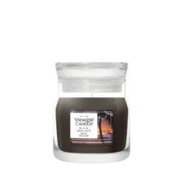 Una candela in vasetto di vetro da 110 g con l'etichetta "Black Coconut - Tumbler Piccolo - Yankee Candle", caratterizzata da cera scura e un unico stoppino bianco.