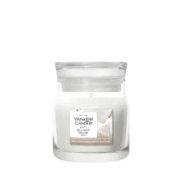 Una piccola candela in bicchiere con l'etichetta “Soft Blanket - Tumbler Piccolo - Yankee Candle” e cera bianca. L'etichetta presenta un motivo dai toni tenui del beige e del bianco, e la candela spenta è raffigurata su uno sfondo bianco.