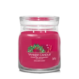 La candela Yankee Candle "Sparkling Winterberry", incastonata in un barattolo di vetro trasparente, presenta un'etichetta elegante decorata con bacche e foglie verdi. Questa candela Giara Media, dotata di due stoppini e del peso di 368 grammi, promette di creare una deliziosa atmosfera invernale.