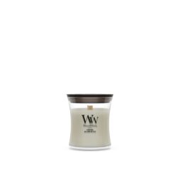 Una candela Woodwick Fireside - Candela Piccola in vetro trasparente, con coperchio in legno e cera bianca, caratterizzata dal logo “WW” nero e dall’etichetta sulla parte anteriore, è raffigurata al centro su uno sfondo bianco.