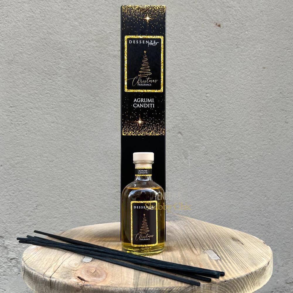 Agrumi Canditi – Dessenze Lab – 100 ml Profumatore per ambiente Un flacone da 100 ml di Agrumi Canditi di Dessenze Lab con tappo in legno, bastoncini diffusori neri e un'alta scatola nera "DES SENS Agrumi Canditi" è esposto su una superficie di legno rotonda contro una parete grigia.