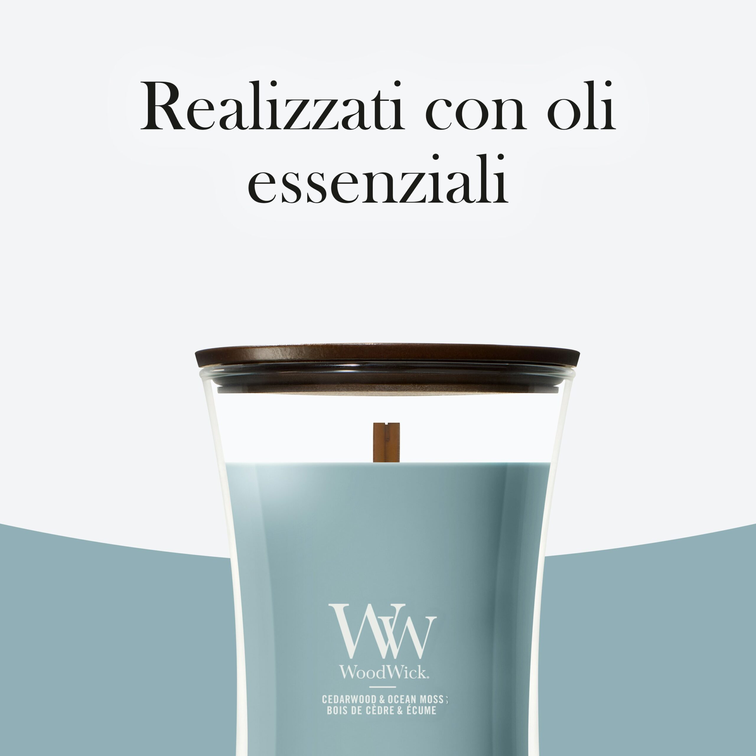 Cedarwood & Ocean Moss – Candela Grande – Woodwick Giara Grande 3 Una candela Candela Grande - Woodwick alla fragranza “Cedarwood & Ocean Moss” (legno di cedro e muschio marino), con coperchio in legno e l’etichetta “Realizzati con oli essenziali” in italiano, è raffigurata sopra la candela. La fragranza unisce il muschio marino rinfrescante alle note di legno di cedro, creando un’atmosfera tranquilla.
