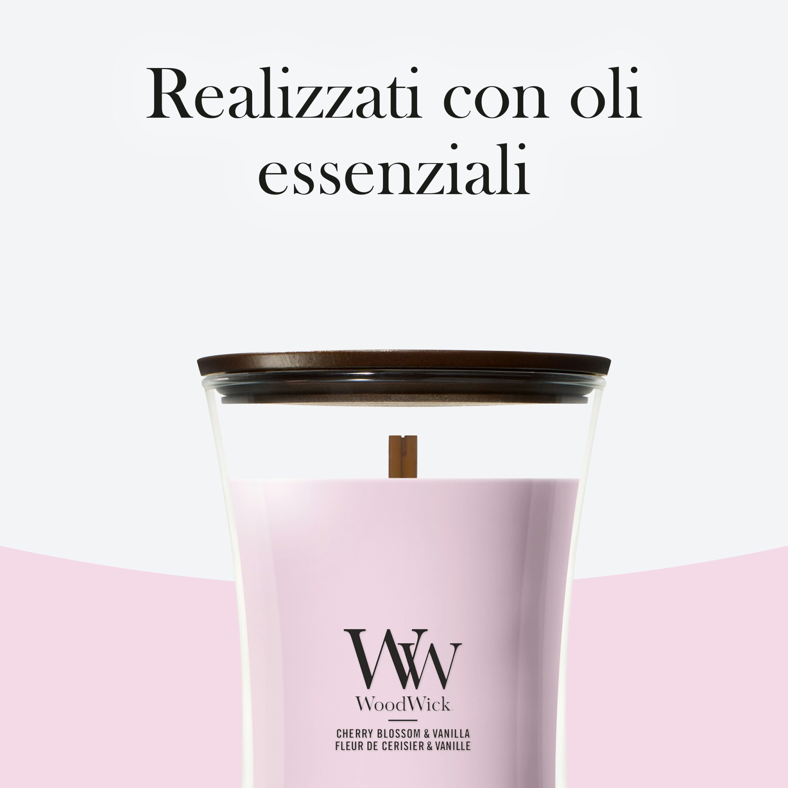 Cherry Blossom And Vanilla – Candela Grande – Woodwick Giara Grande 3 Una candela “Cherry Blossom And Vanilla - Candela Grande - Woodwick”, caratterizzata da una tonalità rosa e da un coperchio in legno, è esposta su uno sfondo bianco e rosa. Arricchita dalla delicata fragranza dei fiori di ciliegio, questa elegante candela valorizza qualsiasi ambiente. Il testo in italiano sopra recita: “Realizzati con oli essenziali”.