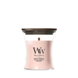 La candela Coastal Sunberry - Candela Piccola - Woodwick è una candela in vetro con coperchio in legno, cera rosa chiaro e stoppino in legno. L'etichetta recita "WoodWick" e "Coastal Sunberry Baies de Morelle Maritimes".