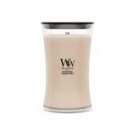 Una candela WoodWick Crystal Ginger color crema della collezione Candela Grande è contenuta in un barattolo di vetro dalla forma ricurva con coperchio nero. Sulla parte anteriore sono stampate le iniziali “WW” e le informazioni sul prodotto, che ne sottolineano la rinfrescante fragranza Crystal Ginger.