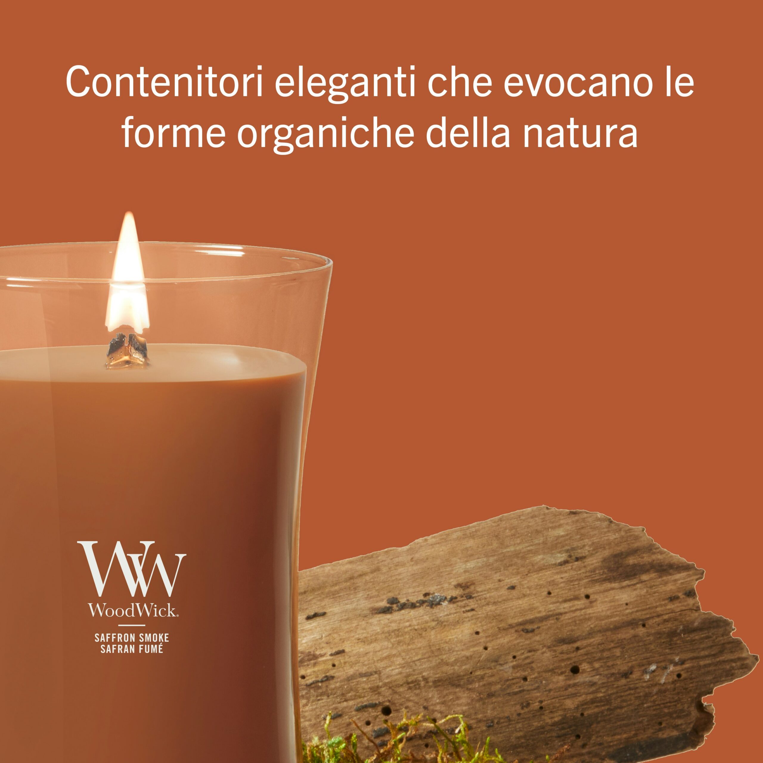 Saffron Smoke – Candela Grande – Woodwick Giara Grande 3 Una candela "A Saffron Smoke - Candela Grande - Woodwick", di un ricco colore marrone e sormontata da un coperchio in legno, è appoggiata accanto a un pezzo di legno su uno sfondo arancione, mentre il testo in italiano sopra descrive questi eleganti contenitori ispirati alla natura.