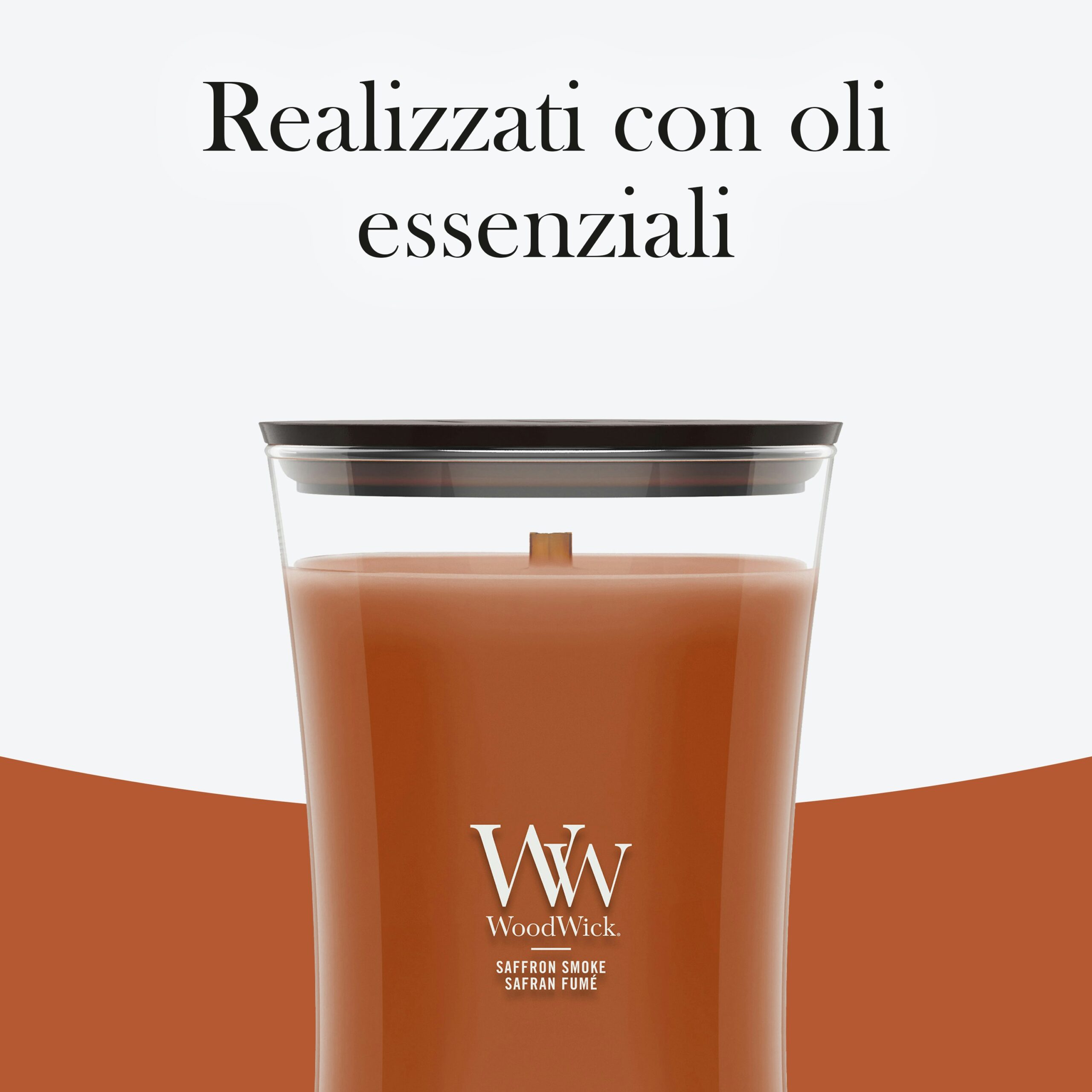 Saffron Smoke – Candela Grande – Woodwick Giara Grande 2 Una candela grande "Saffron Smoke" di WoodWick, contenuta in un elegante vaso di vetro trasparente, reca la scritta "Realizzati con oli essenziali" in italiano. Questa candela profumata avvolge l’ambiente in una fragranza lussuosa e offre il caratteristico crepitio dello stoppino WoodWick.