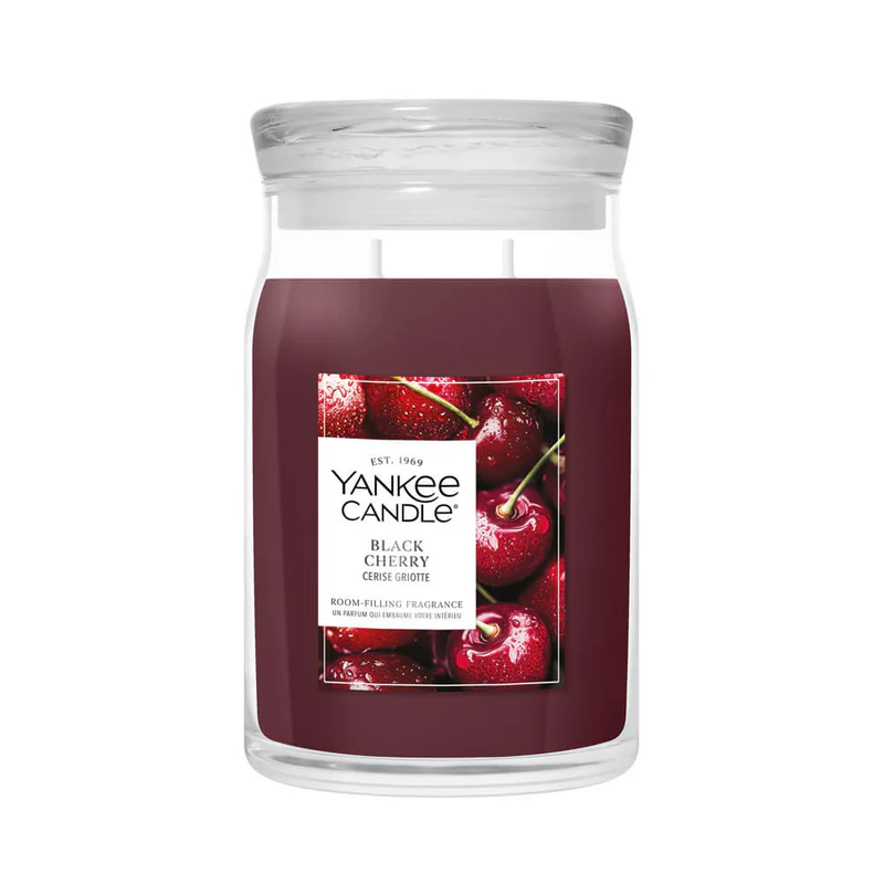 Black Cherry – Candela Grande – Yankee Candle 350 Punti Una grande candela in barattolo di vetro con l'etichetta "Black Cherry - Candela Grande - Yankee Candle" riporta l'immagine di ciliegie fresche. Il barattolo trasparente è riempito di cera rosso intenso e chiuso da un coperchio trasparente.