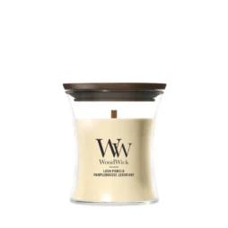 A Lush Pomelo - Candela Piccola di WoodWick, caratterizzata da un coperchio in legno marrone e da cera color crema contenuta in un recipiente di vetro dalla forma ricurva. L'etichetta recita "WoodWick Lush Pomelo Pamplemousse Luxuriant", unendo un design elegante alla fragranza vivace di Lush Pomelo.