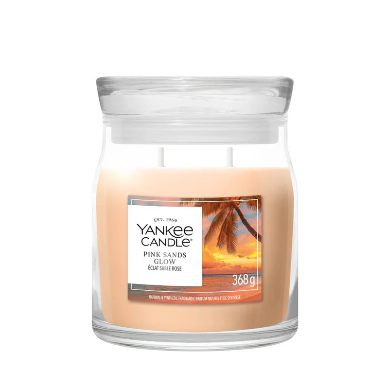 Pink Sands Glow – Candela Media – Yankee Candle 250 Punti La candela in barattolo di vetro “Pink Sands Glow” di Candela Media (Yankee Candle) raffigura una scena da spiaggia con palme e cera rosa chiaro in un barattolo da 368 g con coperchio trasparente.