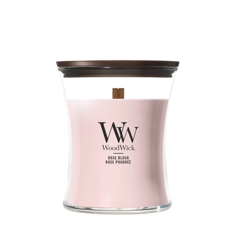 Rose Blush – Candela Media – Woodwick Giara media Una candela WoodWick denominata "Rose Blush" di Candela Media, contenuta in un barattolo di vetro trasparente a forma di clessidra con cera rosa, coperchio in legno marrone e lo storico stoppino in legno.