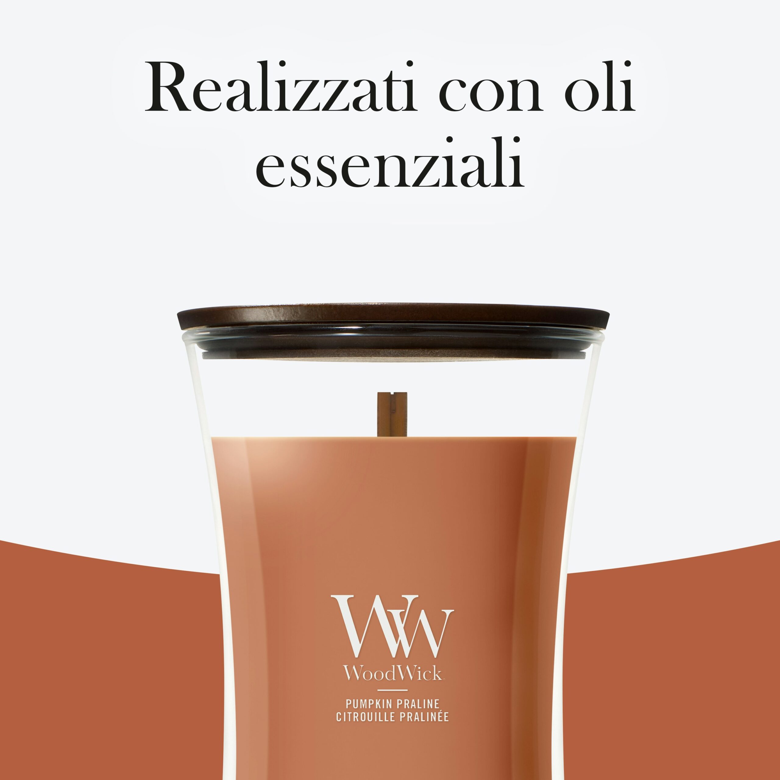 Pumpkin Praline – Candela Grande – Woodwick Giara Grande 5 Una pralina alla zucca - Candela Grande - Woodwick, con coperchio in legno, è raffigurata su uno sfondo bianco e marrone. Il testo in italiano sopra recita: "Realizzati con oli essenziali".