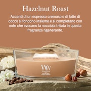 Hazelnut Roast – Ellipse – Woodwick Ellipse 2 La candela “Hazelnut Roast - Ellipse - WoodWick” poggia su tavole di legno decorate con nocciole, pezzetti di cioccolato e fiori delicati. Il testo in italiano ne sottolinea l’aroma cremoso di caffè espresso e cocco, arricchito da intense note di nocciola.