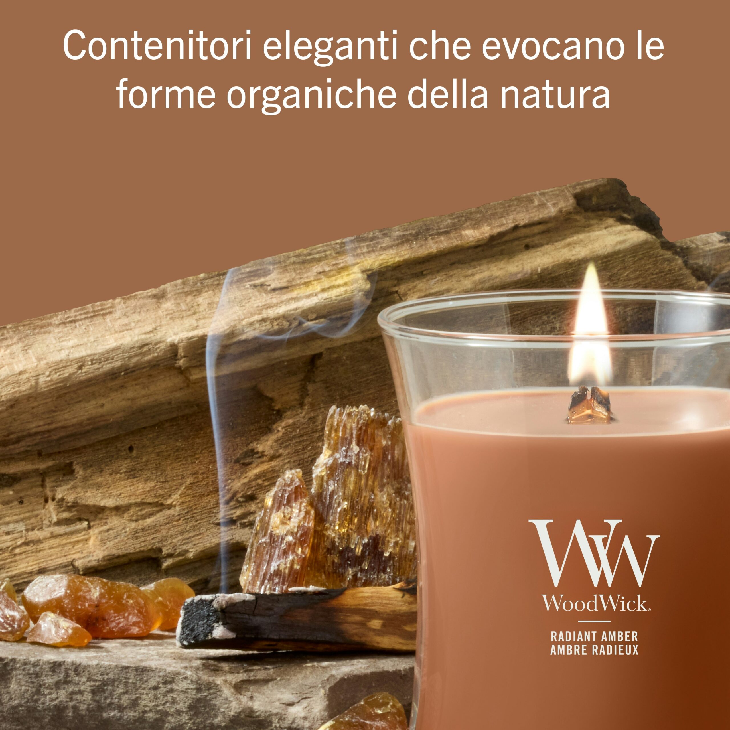 Radiant Amber – Candela Media – WoodWick Giara media 5 A Radiant Amber" - Candela Media - Candela WoodWick di colore marrone, raffigurata mentre arde accanto a lucenti pietre d'ambra, incenso e legno rustico, con un testo in italiano in alto che descrive eleganti contenitori ispirati alle forme naturali.