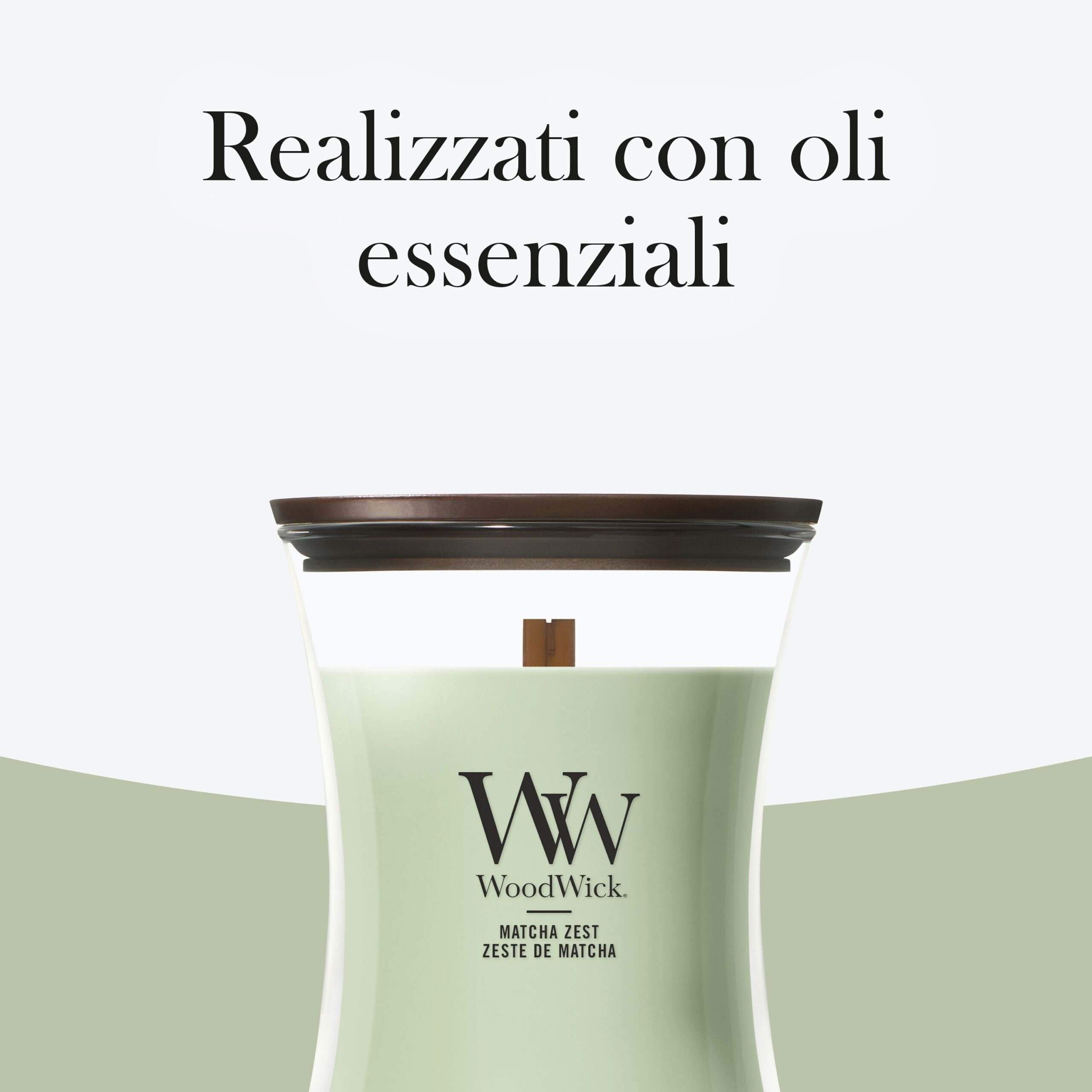 Matcha-Zest Candela Media – Woodwick Giara media 3 Una candela verde Matcha-Zest Candela Media - WoodWick, dotata di stoppino in legno e con l'etichetta "MATCHA ZEST", è raffigurata su uno sfondo chiaro. Sopra di essa, una scritta in italiano recita: «Realizzati con oli essenziali». La fragranza rivitalizzante Matcha-Zest dona un tocco rinfrescante a qualsiasi ambiente.