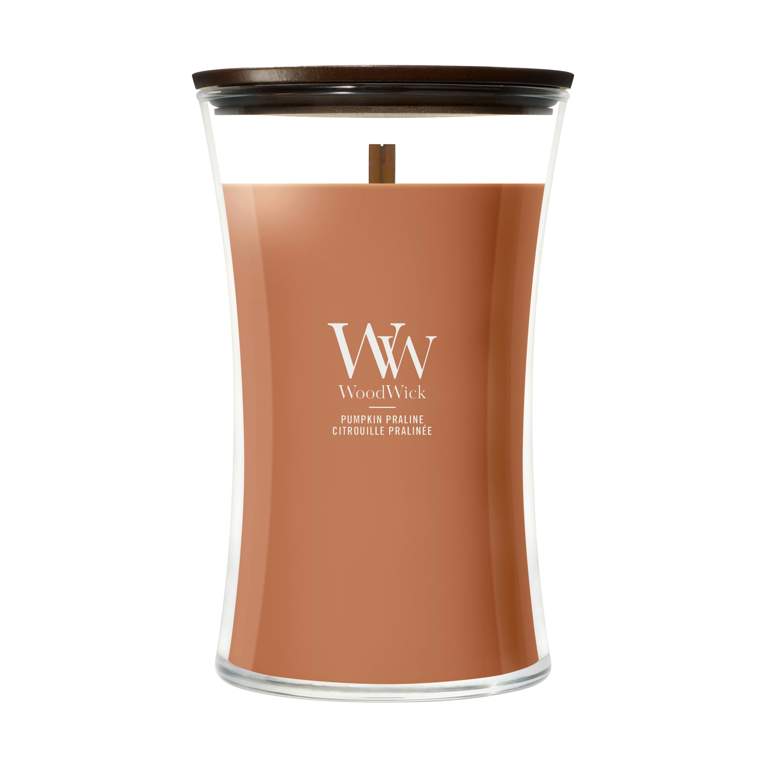 Pumpkin Praline – Candela Grande – Woodwick Giara Grande 6 Una candela WoodWick "Pumpkin Praline - Candela Grande" di grandi dimensioni, con coperchio in legno e cera di colore marrone-arancio. Il barattolo di vetro curvo presenta il logo WoodWick e il nome della fragranza stampati sulla parte anteriore.