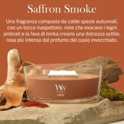 Una candela WoodWick Saffron Smoke - Ellipse poggia su una superficie di legno, circondata da un ceppo rustico e da erbe autunnali. Sopra, una descrizione in italiano della fragranza crea l’atmosfera, mentre la delicata luce ellittica della candela proietta ombre calde, accentuando le ricche note di zafferano della scena.