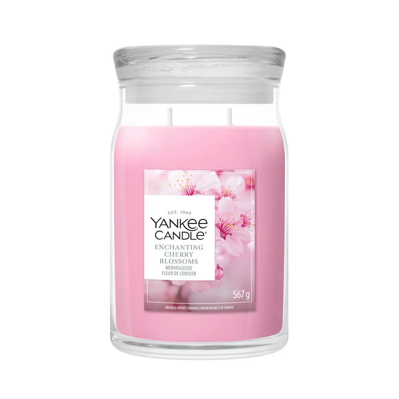 Enchanting Cherry Blossoms – Candela Grande -Yankee Candle 350 Punti Un grande barattolo Yankee Candle Candela Grande alla fragranza “Enchanting Cherry Blossoms”, contenente una candela rosa con un’etichetta raffigurante delicati fiori di ciliegio e una scritta bianca, chiusa da un coperchio trasparente.