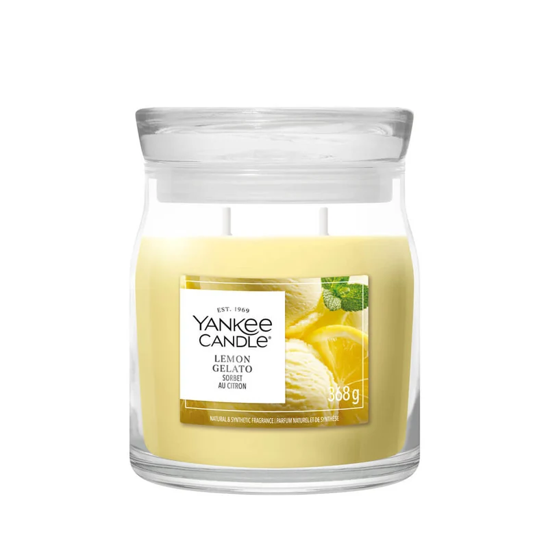 Lemon Gelato – Candela Media – Yankee Candle 250 Punti Una candela Yankee Candle “Lemon Gelato - Candela Media” da 368 g, contenuta in un barattolo di vetro giallo, dotata di due stoppini e con un’etichetta sul davanti raffigurante fette di limone e foglie di menta.